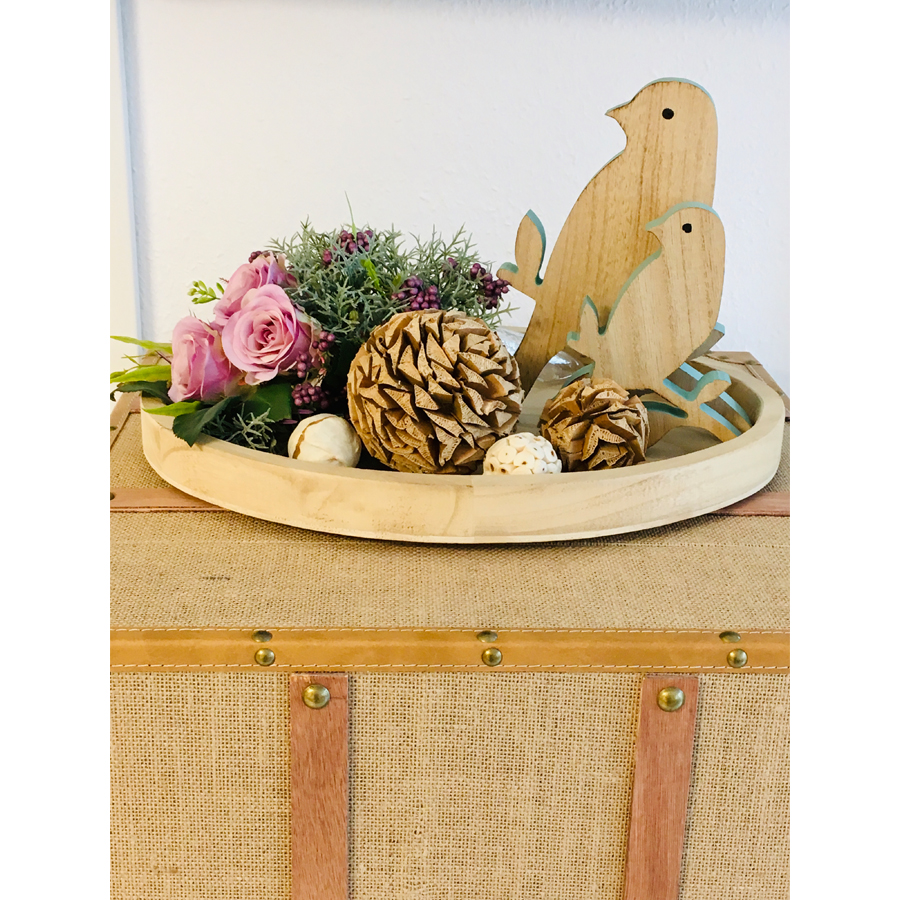 Detailansicht der Dekoration auf einem Holz-Überseekoffer mit Vogel, Tannenzapfen und Rosenbouquet im Apartment in Konstanz am Bodensee